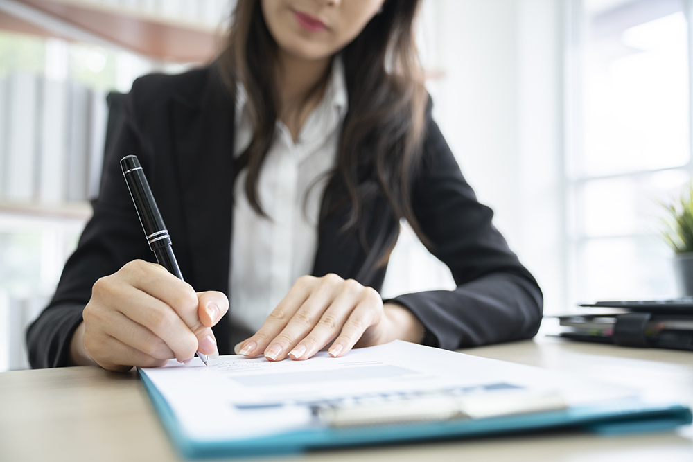 image of a woman signing a contract