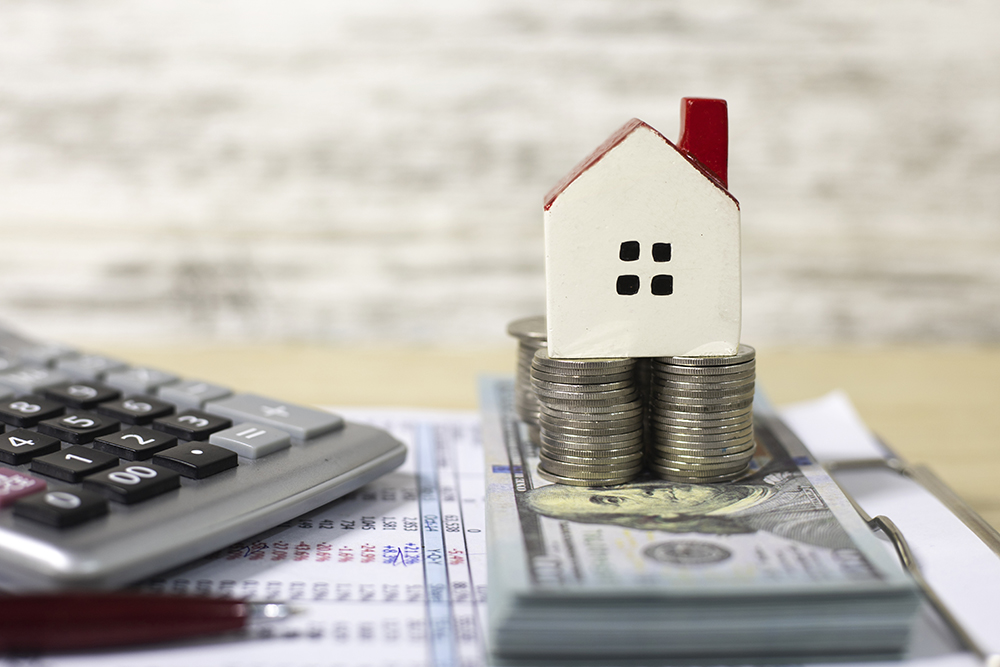image of a model house on top of money