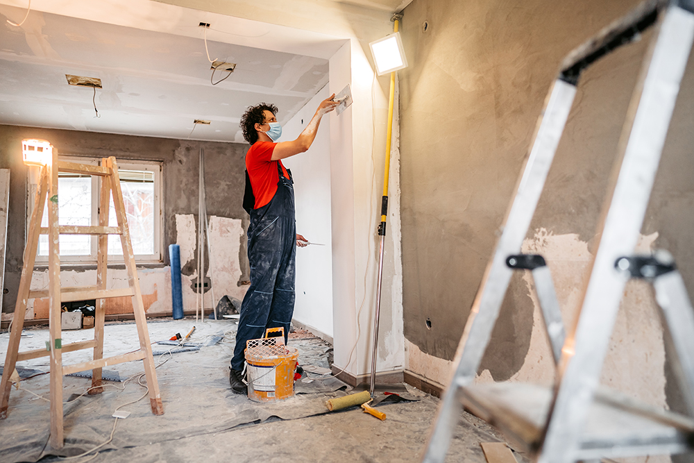 image of a man working on drywall