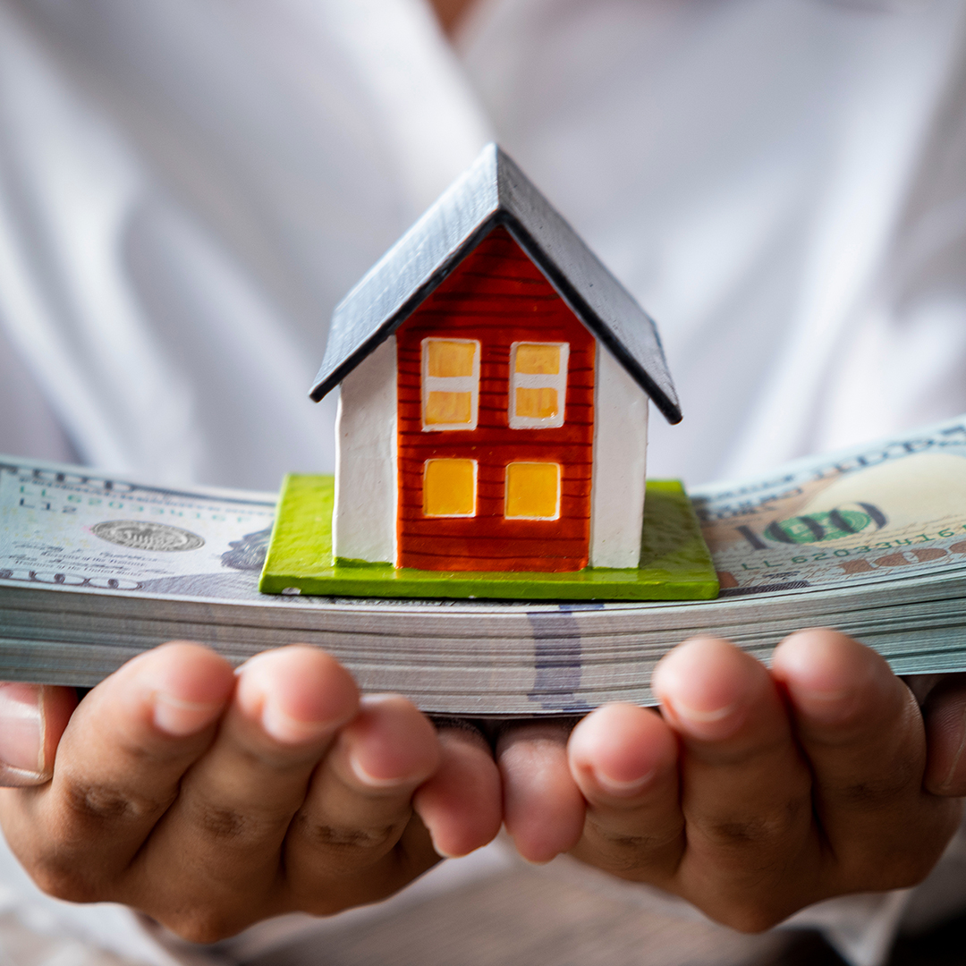Image of a model house on stacks of cash