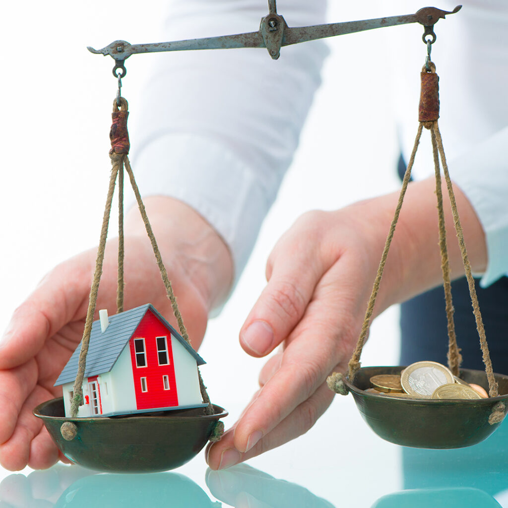 Image of a scale with a house outweighing money