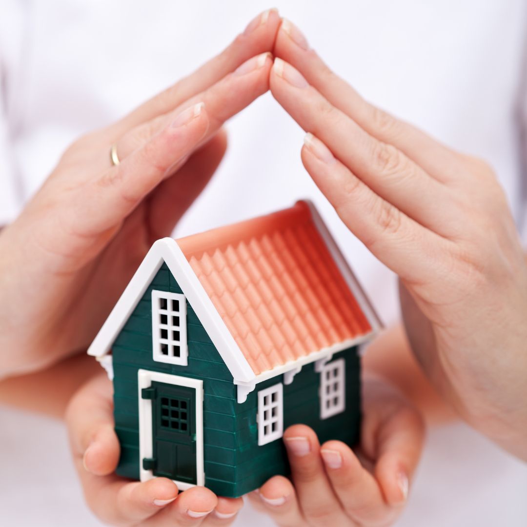 hands cover house